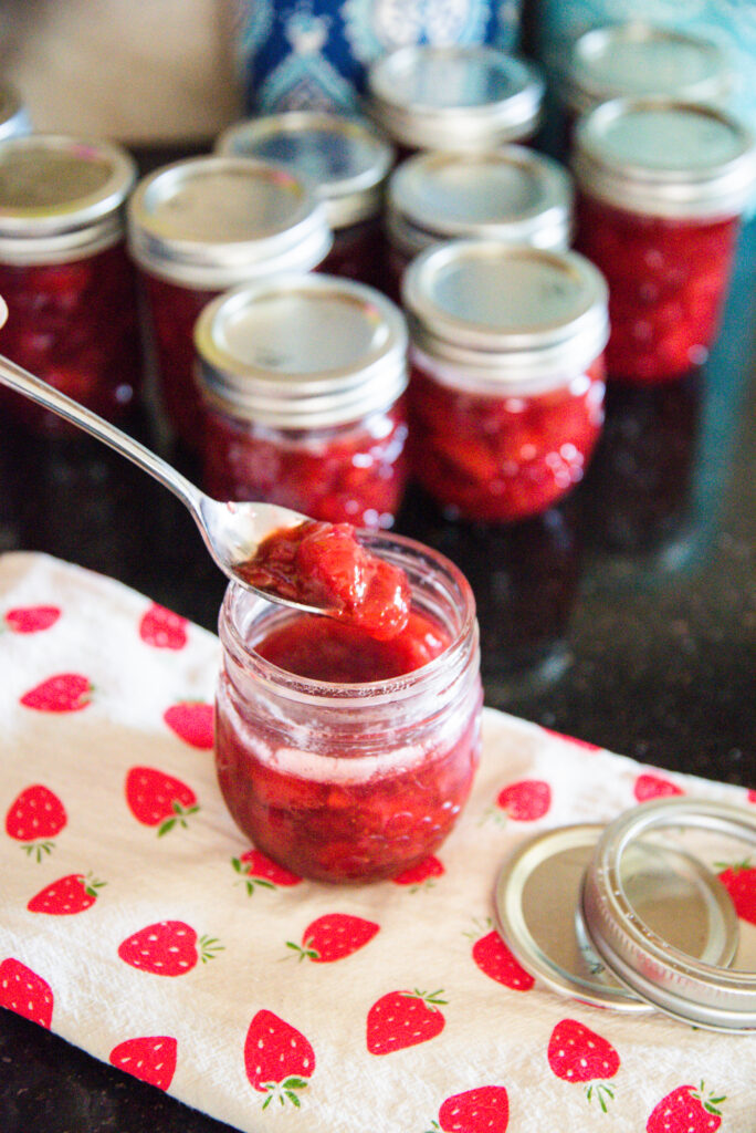 Jars of strawberry preserves on a strawberry patterned towel